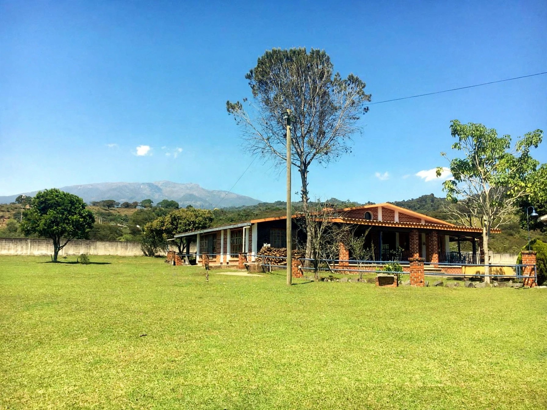 The main house and its grounds with the mountains of the coffee highlands behind
